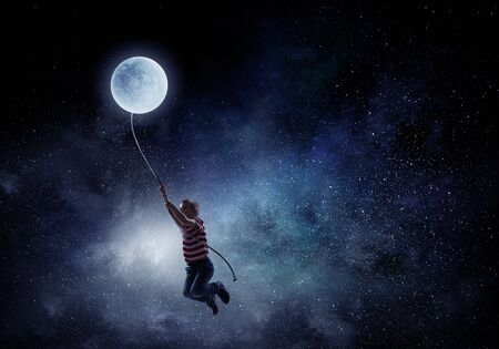 Boy of school age flying moon balloon. Mixed mediaの写真素材
