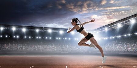 Sport woman running on stadium track. Mixed mediaの写真素材