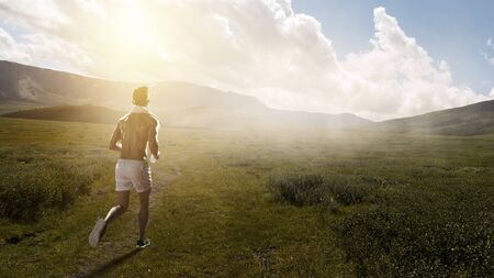 Young athlete running outdoor on countryside road. Mixed mediaの写真素材