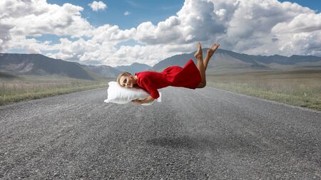 Young elegant woman flying on pillow. Mixed media