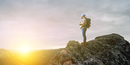 Male tourist with backpack reaching the top. Mixed media