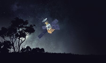 Satellite flying in dark starry sky. Mixed mediaの写真素材