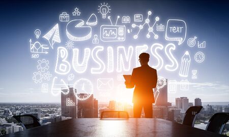 Businessman and drawn strategy against modern cityscapeの写真素材