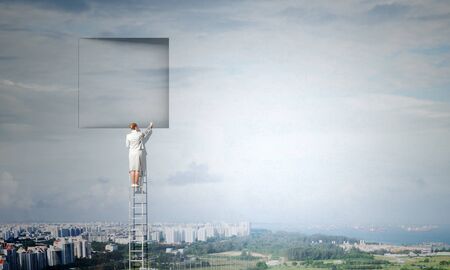 Businesswoman standing on ladder and climbing up to window. Mixed mediaの写真素材