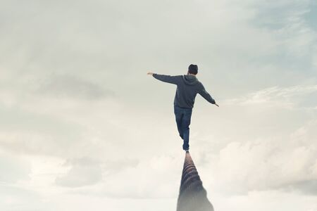 Man wearing virtual reality goggles and balancing on rope