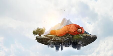 Young traveler in sleeping bag. Travel concept. Mixed mediaの写真素材