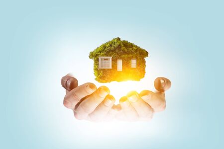 Hand holding green house. Mixed mediaの写真素材