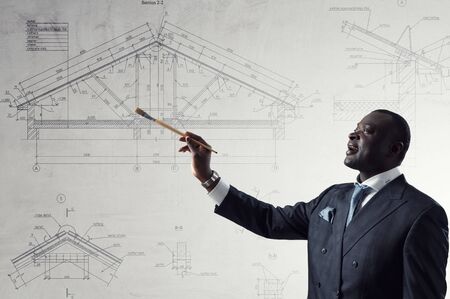 Conceptual image of ambitious and creative businessman in black suit holding paintbrush in handの写真素材