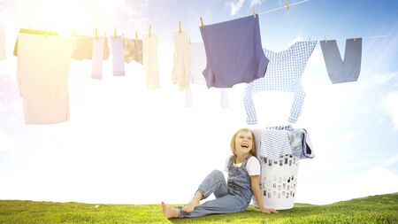 Happy little girl with washed clothesの写真素材