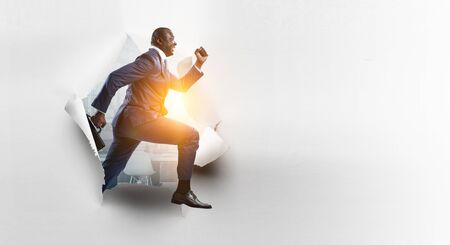 Black businessman breaking paper wallの写真素材