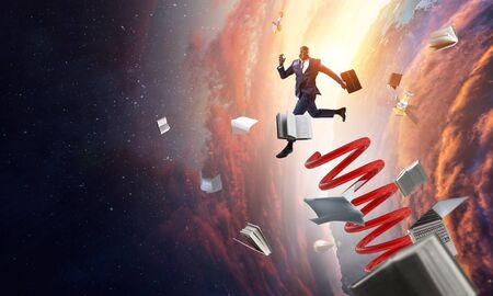 Businessman jumping on springboard as symbol of progress. Mixed mediaの写真素材