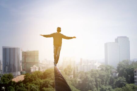 Man wearing virtual reality goggles and balancing on ropeの写真素材