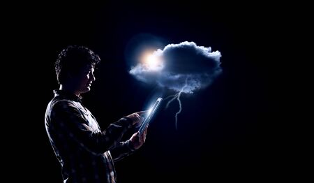 Man holding cloud with lighteningの写真素材