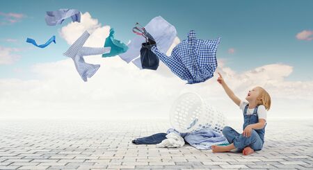 Happy little girl with washed clothesの写真素材