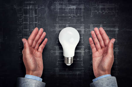 Light bulb between hands . Mixed mediaの写真素材