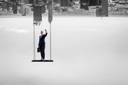 Businesswoman standing against cityscape and making selfieの写真素材