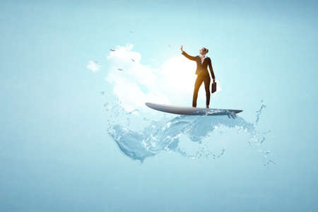 Businesswoman standing on surfing board and making selfie. Mixed mediaの写真素材
