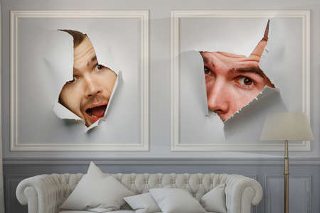 Male face through the hole in paper