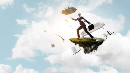 Young businesswoman walking with umbrellaの写真素材