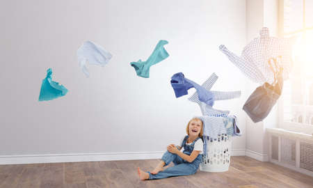 Happy little girl with washed clothesの写真素材