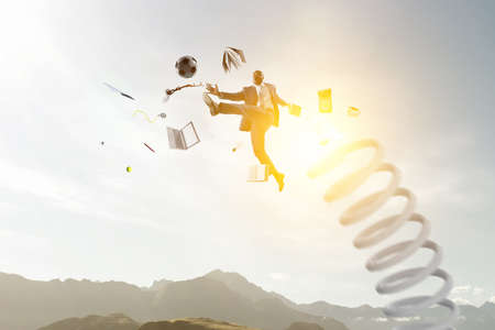 Businessman jumping on springboard . Mixed media