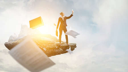 Businesswoman standing against landscape and making selfieの写真素材