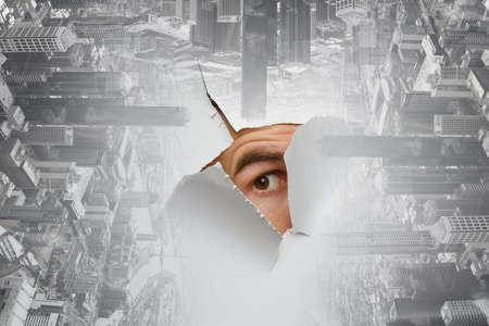 Male face through the hole in paper