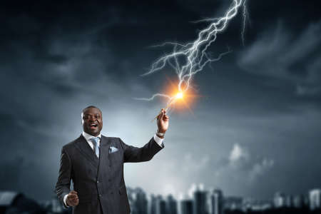 Conceptual image of ambitious and creative businessman in black suit holding paintbrush in handの写真素材