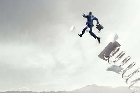 Businessman jumping on springboard . Mixed mediaの写真素材