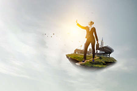 Businesswoman standing against landscape and making selfieの写真素材