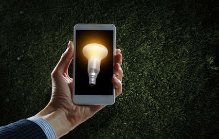 Light bulb on phone screenの写真素材