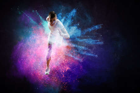 Portrait of a fitness man running on a colourful backgroundの写真素材