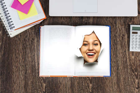 Female face through the hole in paperの写真素材