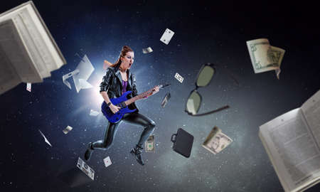 Young and beautiful rock girl playing the electric guitar