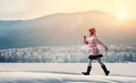 Little girl walking a winter landscapeの写真素材