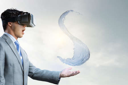 Man wearing virtual reality goggles and water splashの写真素材