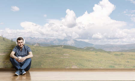 Young man sitting on the floor, a moment for relax concept. Mixed mediaの写真素材