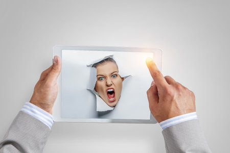 Male face through the hole in paperの写真素材