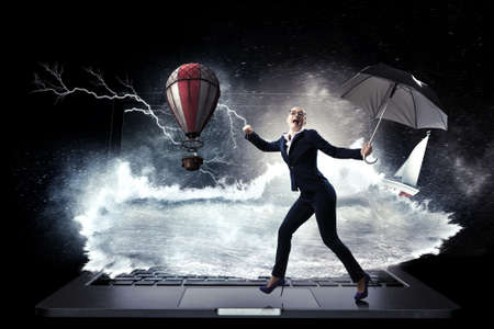 Young businesswoman walking with umbrellaの写真素材