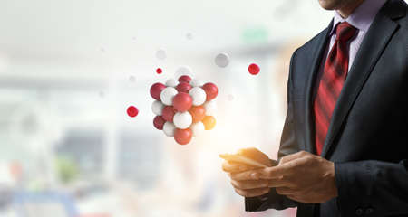 Businessman holding a tabalet with a bunch of spheres levitating above. Mixed media . Mixed mediaの写真素材