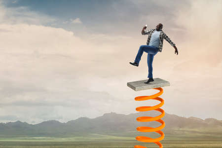 Businessman jumping on springboard . Mixed mediaの写真素材