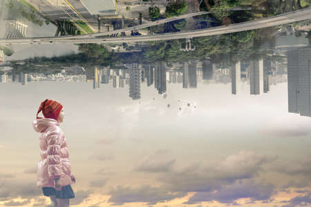 Little girl walking with city at backgroundの写真素材