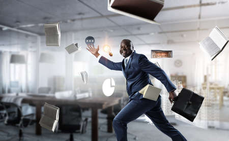 Running black businessman with briefcaseの写真素材