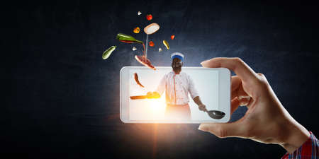 Chef cooking on mobile screen . Mixed media