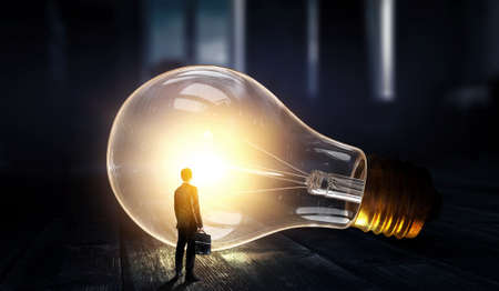 Huge light bulb glowing in the darkness .の写真素材