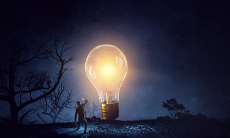 Huge light bulb glowing in the darkness