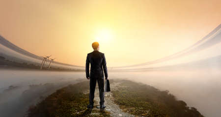 Businessman standing in front of landscape. Mixed media