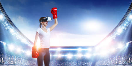 Young woman boxing in VR glasses . Mixed media