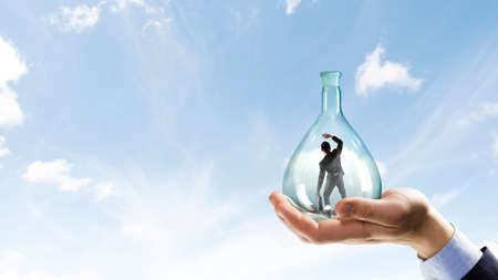 Businessmen scared inside glass bottle