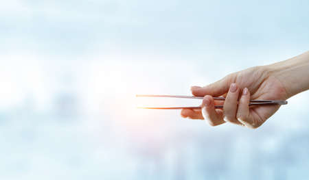 Human hand with metal pincersの写真素材